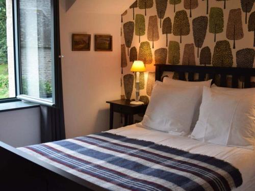 a bedroom with a bed with a striped blanket and a window at Métairie du Manoir Comfortable holiday residence in Le Vieux-Marché
