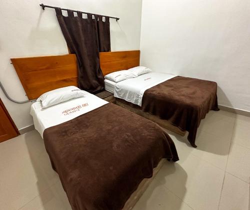 two beds in a hotel room withskirts at LA PLAZOLETA in Doradal