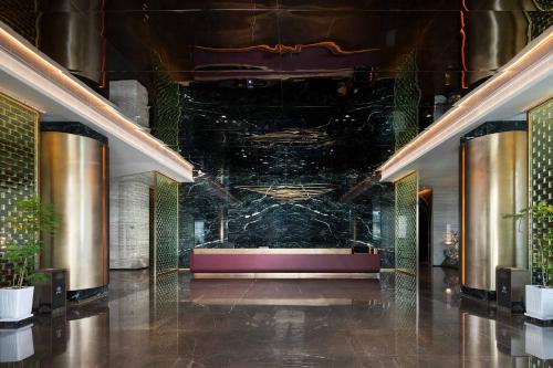 a lobby of a building with a marble wall at 黄石未苏湾花间亭飞花 in Xialu