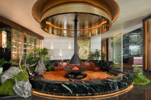 a lobby with a couch and a large chandelier at 黄石未苏湾花间亭飞花 in Xialu