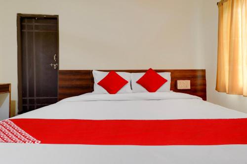 a bed with red pillows and a red blanket at HOTEL O SHAZEB INTERNATIONAL in Hyderabad