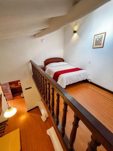 a bedroom with a bed and a stairwell with a bed sidx sidx at Hotel Cusco Plaza Saphi in Cusco