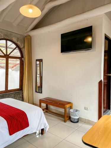 a bedroom with a bed and a tv on the wall at Hotel Cusco Plaza Saphi in Cusco