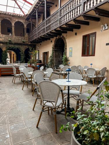 a patio with tables and chairs in a building at Hotel Cusco Plaza Saphi in Cusco