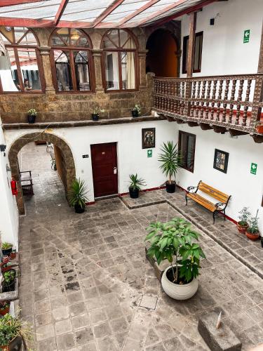 an empty courtyard with a bench and potted plants at Hotel Cusco Plaza Saphi in Cusco