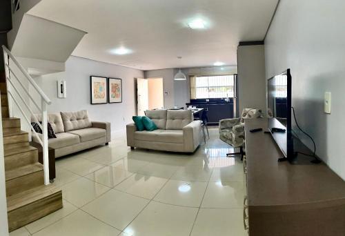 a living room with two couches and a table at Casa 2 Suítes+1 - VISTA MAR e 15km do Beto Carrero - 50 metros da PRAIA - Area de LAZER com Churrasqueira - Wi-Fi e Cozinha Completa in Piçarras