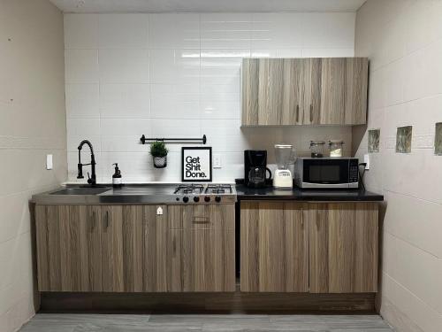 a kitchen with a sink and a microwave at House Hotel Stadium in Guadalajara