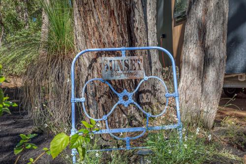 a blue bench sitting in front of a tree at Jarrah Valley Escape by Tiny Away in Bedfordale