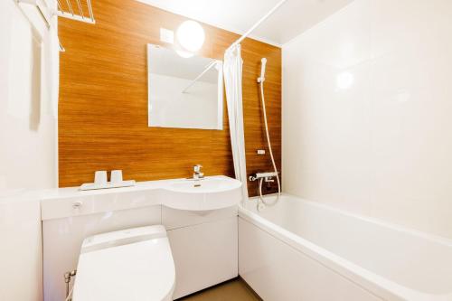a bathroom with a white toilet and a sink at KAMENOI HOTEL Nara in Nara