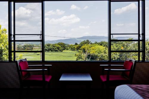 a room with two chairs and a table and a window at KAMENOI HOTEL Nara in Nara