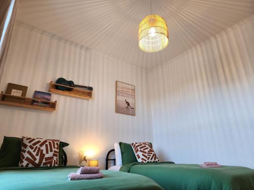 a living room with two green beds and a light at MKM Villa - Cozy House in Central Lower Hutt in Lower Hutt
