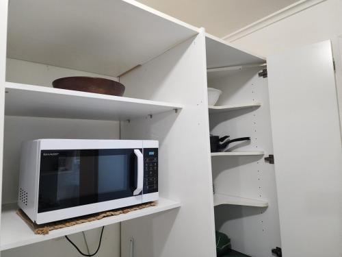 a microwave sitting on a shelf in a kitchen at MKM Villa - Cozy House in Central Lower Hutt in Lower Hutt