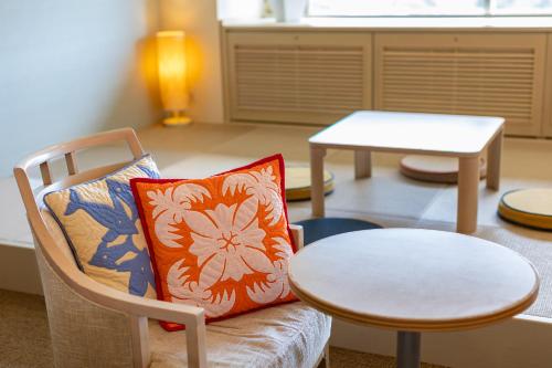 a living room with a chair and a table at Spa Resort Hawaiians Monolith Tower in Iwaki