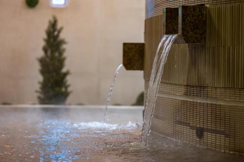 a fountain with water coming out of a building at Spa Resort Hawaiians Monolith Tower in Iwaki