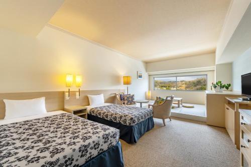 a hotel room with two beds and a window at Spa Resort Hawaiians Monolith Tower in Iwaki