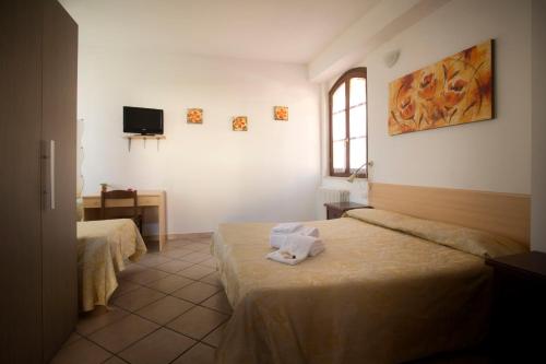 a hotel room with two beds and a window at Soggiorno La Primula in Siena