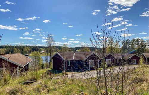 una fila de casas en un campo junto a un cuerpo de agua en Nice Home In Hokjönköpingskillingaryd, en Svenstorp
