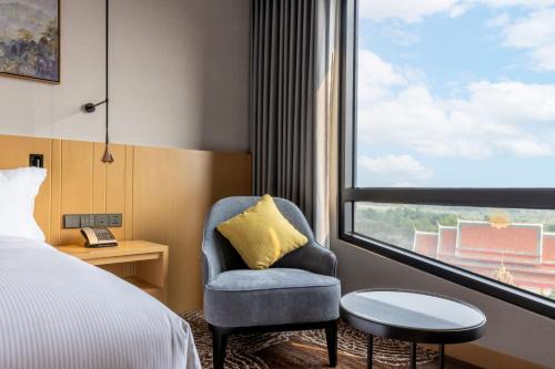 a hotel room with a chair and a window at DoubleTree by Hilton Vientiane in Vientiane