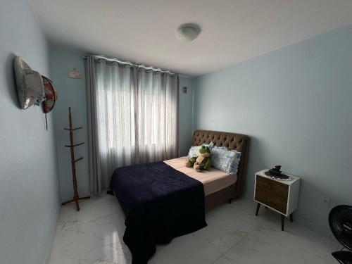 a bedroom with a teddy bear sitting on a bed at Apartamento Aconchegante Central (Borboleta) in Itajaí