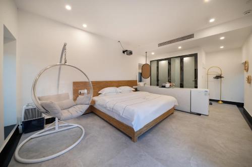 a large bedroom with a bed and a chair at 平潭游记猫头墘古村落 in Pingtan