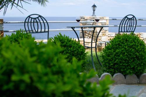 two chairs and a table with a view of the ocean at Guesthouse Enastron in Chorefto