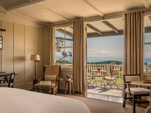 a hotel room with a bed and a large window at Rosewood Cape Kidnappers in Te Awanga