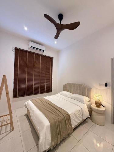 a bedroom with a ceiling fan and a bed at Casa Anggeriani in Jitra