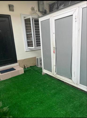 a living room with green carpet and a tv at Emerald Ikate Lekki in Lekki