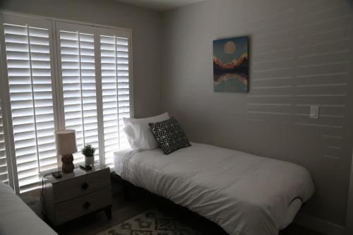 a bedroom with a bed and a window with blinds at Updated 4-bedroom home centrally located in Logan