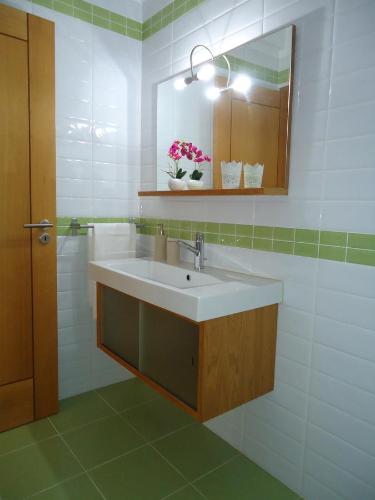 a bathroom with a sink and a mirror at Apartamento Praiamar in Vila Nova de Milfontes