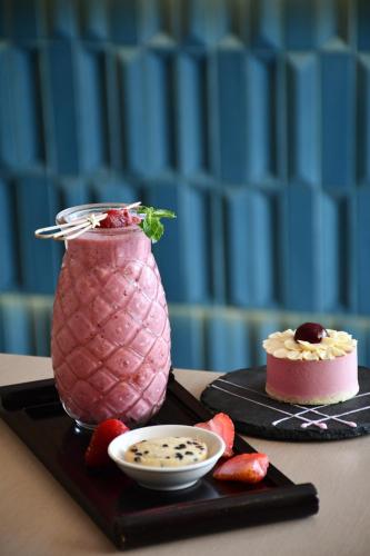 un dessert rose sur un plateau noir avec un gâteau et des fraises dans l'établissement InterContinental Residences Nha Trang by IHG, à Nha Trang