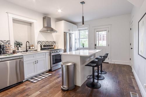 a kitchen with white cabinets and stainless steel appliances at Ann Avenue Charming 3 Bedroom Retreat Near Downtown St Louis in Saint Louis