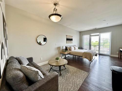 een woonkamer met een bank en een bed bij Downtown Penthouse Loft with View in Indianapolis