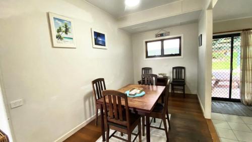 Un comedor con mesa y sillas de madera. en Sholti Wooli, en Wooli