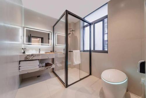 a bathroom with a shower and a toilet and a sink at Flower Whisperer Homestay Tianmenshan Store free airport and station pick-up in Zhangjiajie