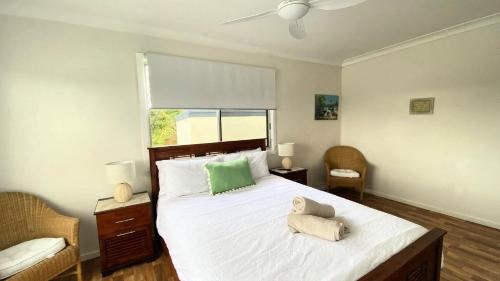 a bedroom with a bed with two stuffed animals on it at Surfside in Wooli