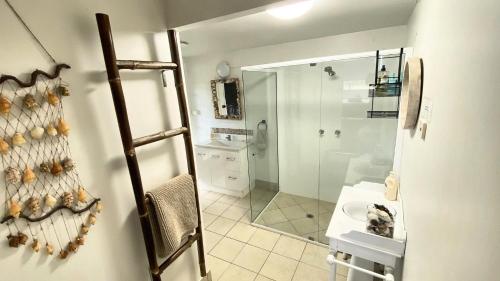 a bathroom with a shower and a sink and a mirror at Surfside in Wooli