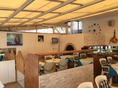 a restaurant with tables and chairs and a clock on the wall at Hotel Vela Azzurra in Malcesine