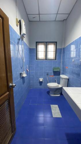 a blue tiled bathroom with a toilet and a sink at Kiang Beach Villa Cha-am in Cha Am
