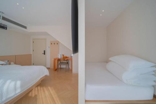 a white bedroom with a bed and a table at Flower Whisperer Homestay Tianmenshan Store free airport and station pick-up in Zhangjiajie
