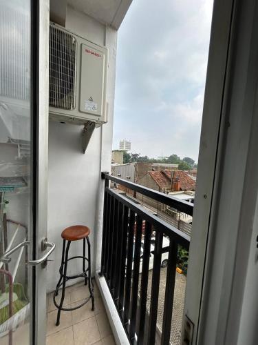 a stool sitting on a balcony with a view at 1BR Plus Sudirman Suite Apart by Metta in Bandung