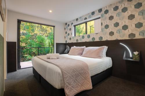 a bedroom with a large bed and a window at Family Size Holiday Home With Remarkable Views & Sauna, Close to Town in Queenstown