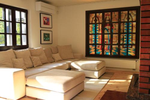 a living room with a couch and a stained glass window at Secluded private villa in the middle of the woods in Margionys