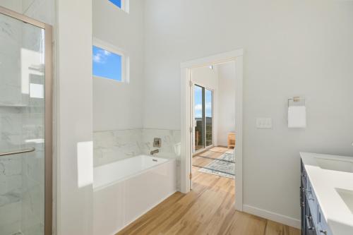 a white bathroom with a tub and a sink at The Beachcomber - Oceanfront Getaway! in Westport
