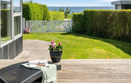 a patio with a table and a potted plant at Awesome Home In Juelsminde in Sønderby