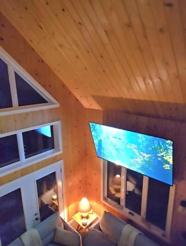 a living room with a large flat screen tv at La Cabane du Couturier in Sainte-ThÃ¨cle