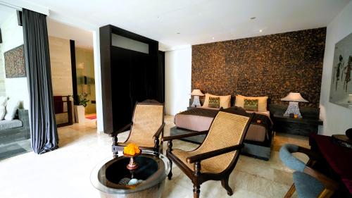 a bedroom with a bed and a table and chairs at Kelapa Retreat & Spa in Pulukan