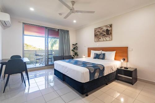 a bedroom with a bed and a desk and a window at Vitina Studio Motel in Darwin