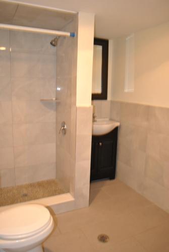 a bathroom with a shower and a toilet and a sink at FAMILY Guest house in Newark