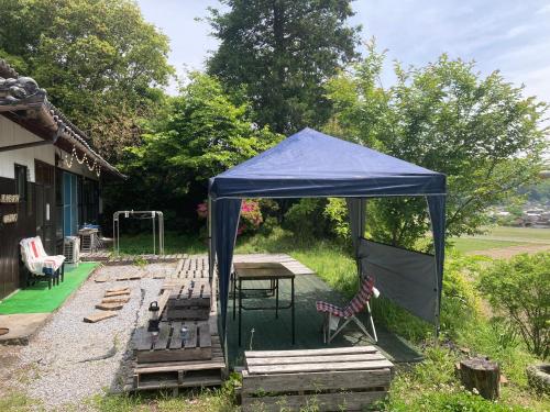 a blue tent with a picnic table and chairs at エコビレッジ地球人村 in Shimoichi